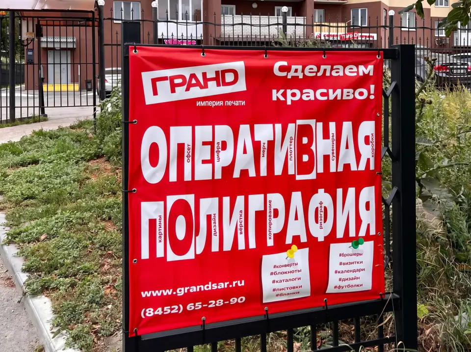 Красный рекламный баннер типографии Гранд на ограждении